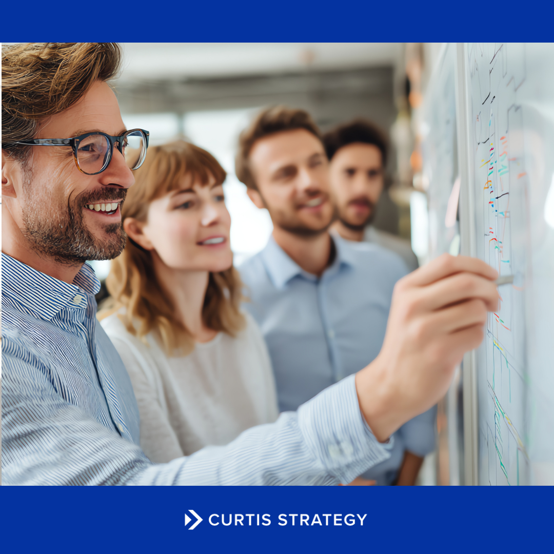 Leadership team reviewing an outcome-driven credit union growth strategy on a whiteboard.