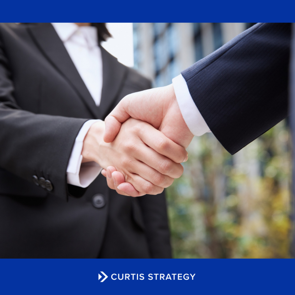 Two nonprofit leaders shaking hands, representing effective succession planning and smooth leadership continuity.